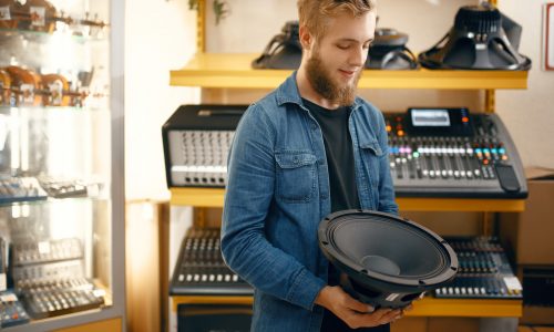 Musician buying subwoofer speaker in music store